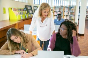 transition to retirement-teacher assisting two students in class