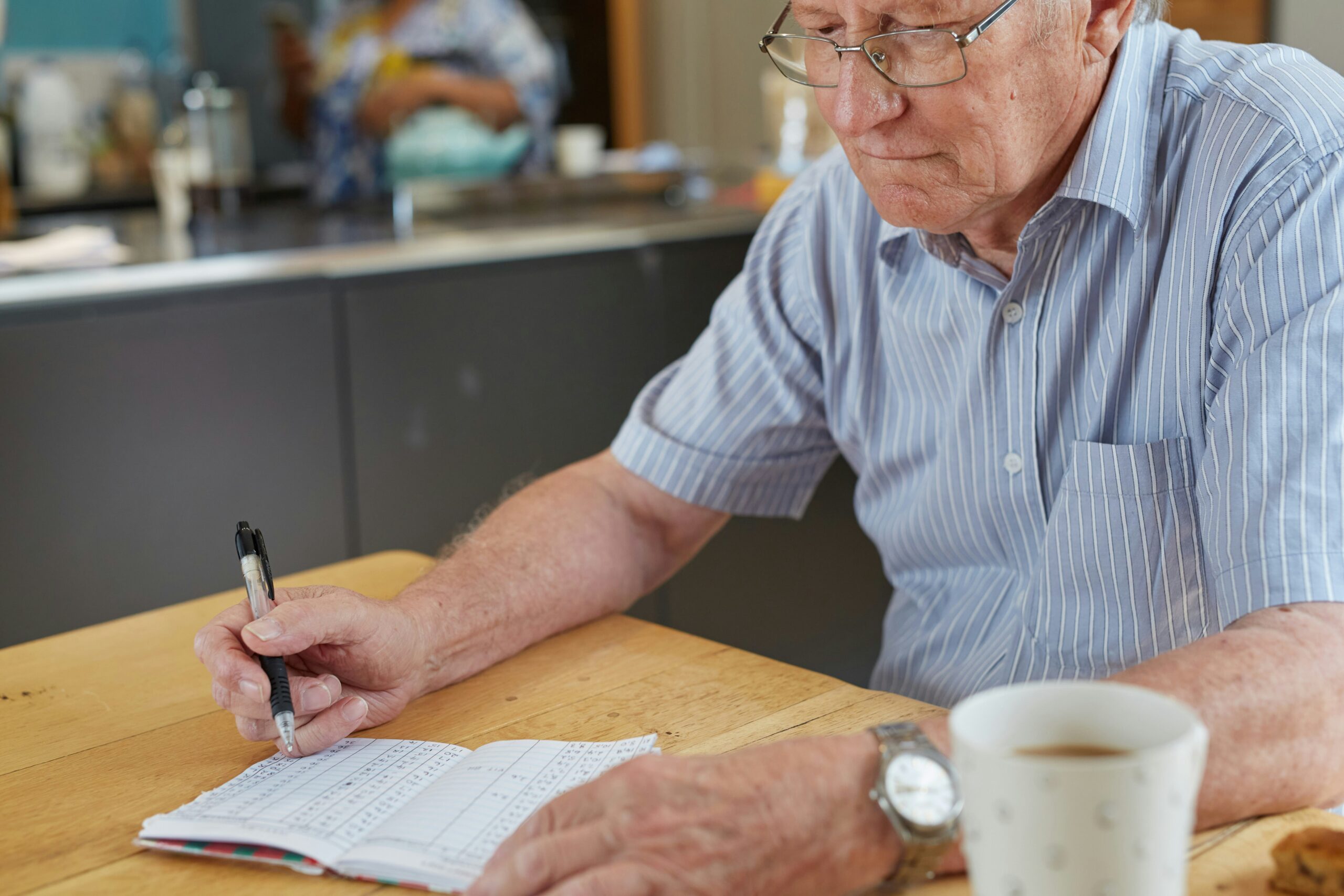 retiring abroad- Older man writing in a notebook