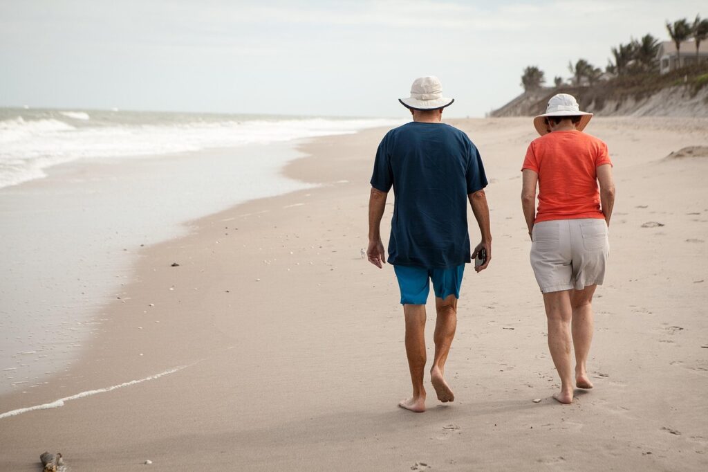 retiring overseas-a couple waks down a sandy beach