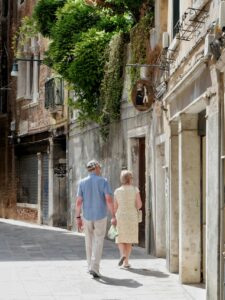 living abroad-elderly couple walking through the streets of Venice, Italy